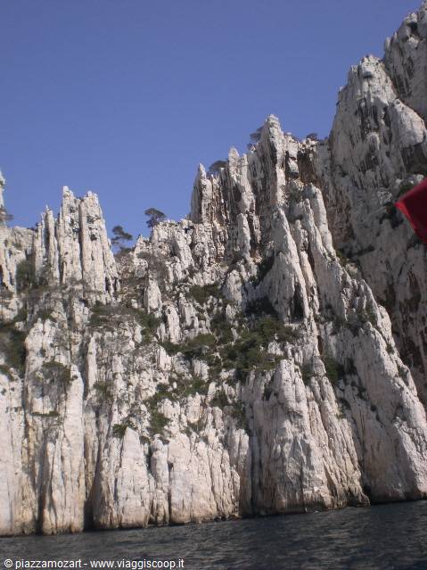 White limestone cliffs of the Calanques, green shrubs, clear blue sky
