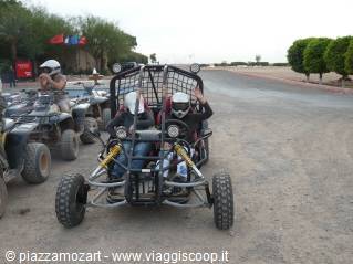 Helmeted tourists on off-road buggies and quads setting out on desert excursion