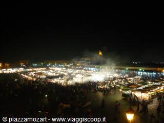 Jemaa el-Fna square at night, smoke and lights from food stalls, lit minaret