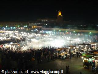 Jemaa el-Fna square at night: smoke from food stalls, crowd and lit minaret