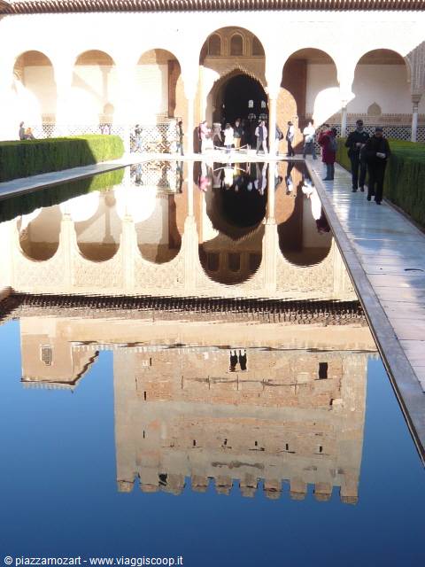 Arches and visitors reflected in the myrtle courtyard pond, Alhambra