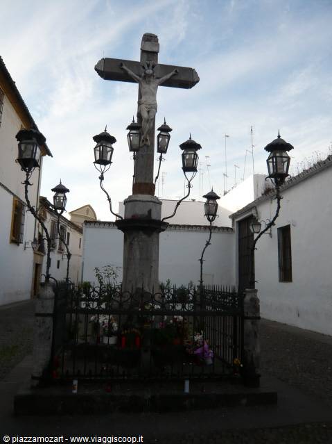 Christ of the Lanterns: stone cross surrounded by iron lanterns in a square
