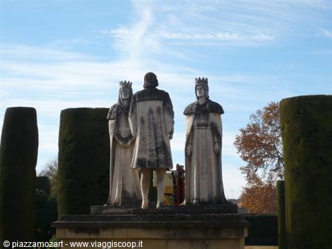 Stone statues of Columbus and Catholic Monarchs among clipped cypresses, Medina del Campo