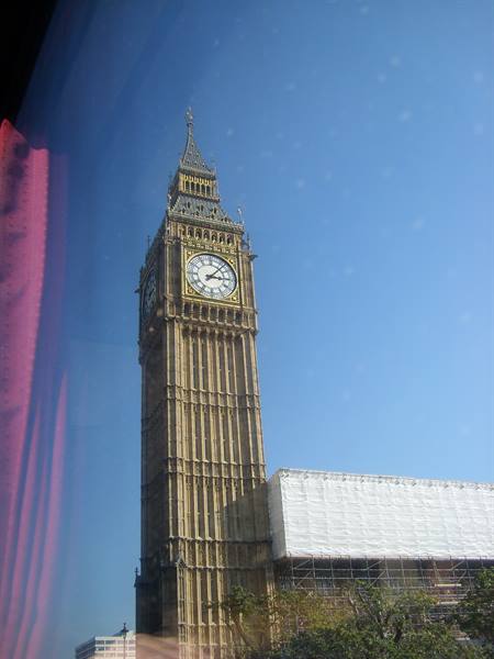 Elizabeth Tower clock photographed through bus window glass, blue sky
