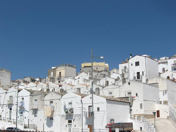 White houses clustered on a hillside under a deep blue sky, Monte Sant'Angelo