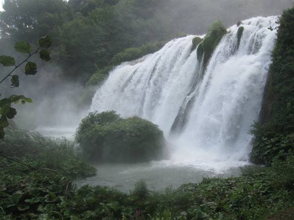 Marmore Falls plunging into misty pool, surrounded by lush greenery