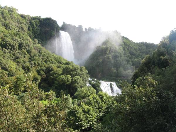 Marmore Falls, white water cascading through green woods in the mist