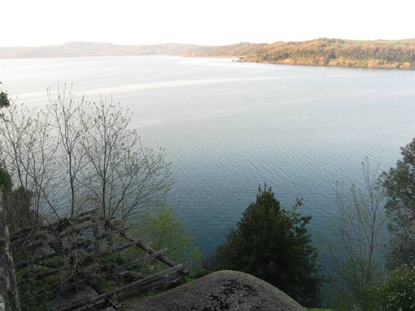 Lake Bracciano seen through bare branches and a wooden pergola