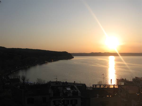 Low sun over Lake Bracciano, rooftops and lakeside promenade backlit