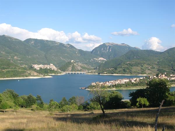 Lake Turano, villages along the shore among green mountains and cloudy sky