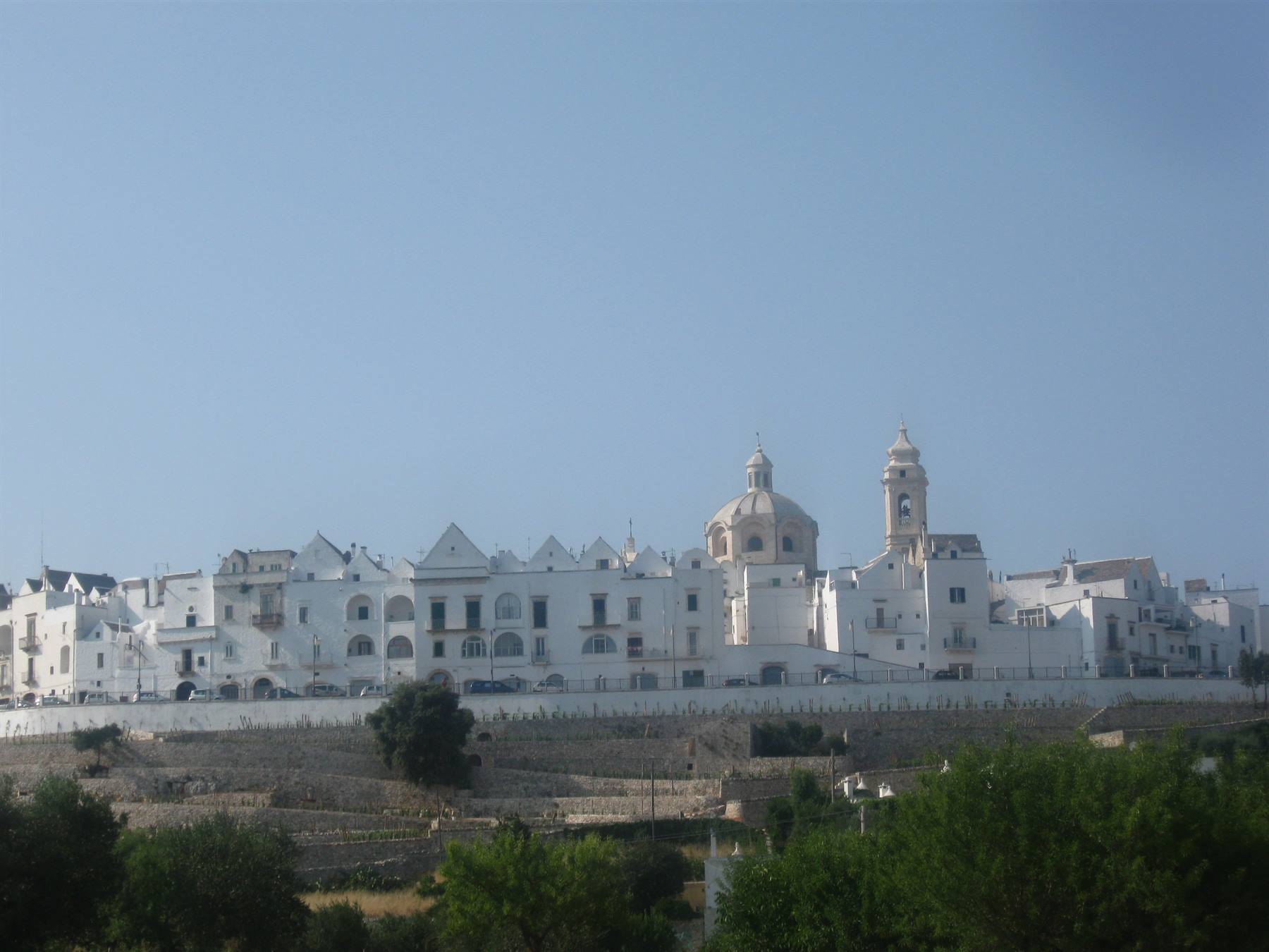 Ostuni, la città bianca: case imbiancate a calce, cupola e campanile sotto il cielo azzurro