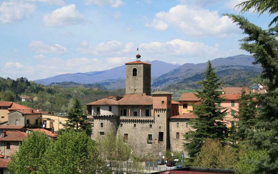 Rocca Ariostesca a Castelnuovo di Garfagnana: torre in pietra tra tetti e colline