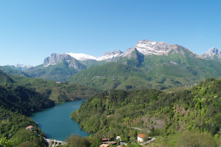 Lago di Vagli con case sparse e le Alpi Apuane innevate