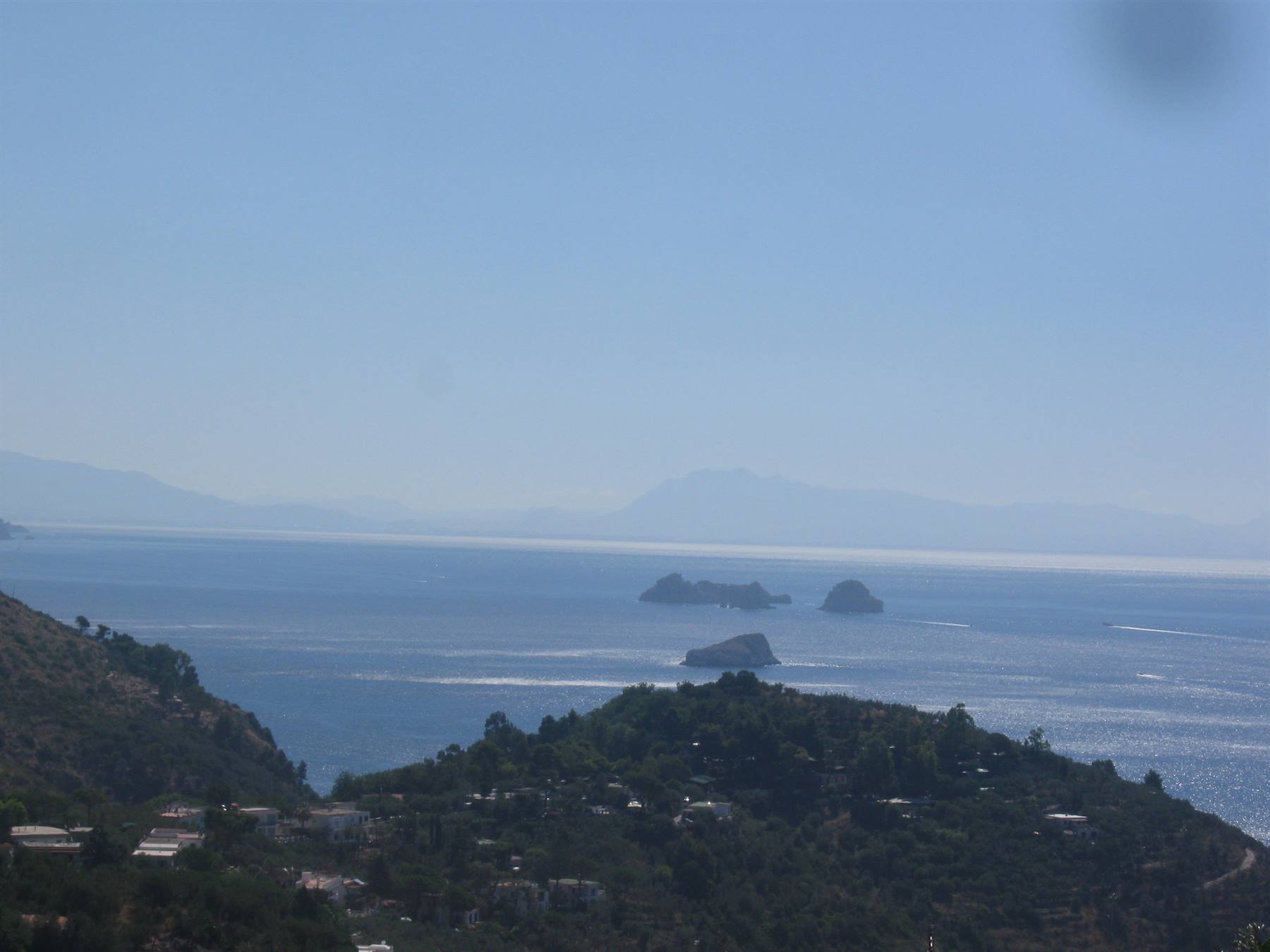 Isole Li Galli sul mare di Capri, verdi colline costiere sotto cielo chiaro