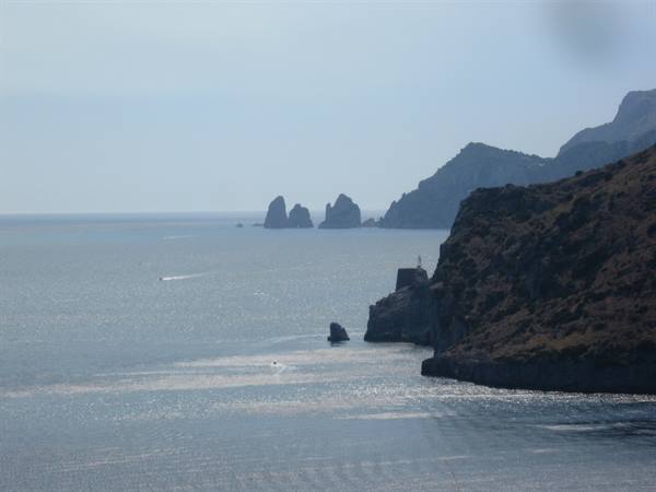 Punta Carena lighthouse and Capri's faraglioni stacks above the glittering sea