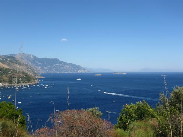 Amalfi Coast: boats on deep blue sea, Li Galli islets ahead, Mediterranean shrubs
