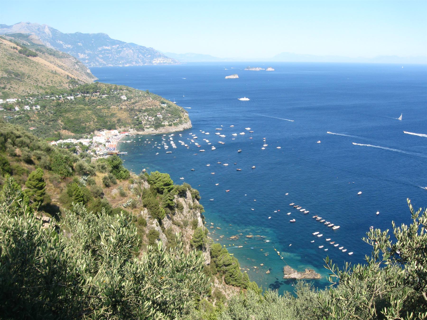 Moltitudine di barche ancorate nella baia blu della Costiera Amalfitana