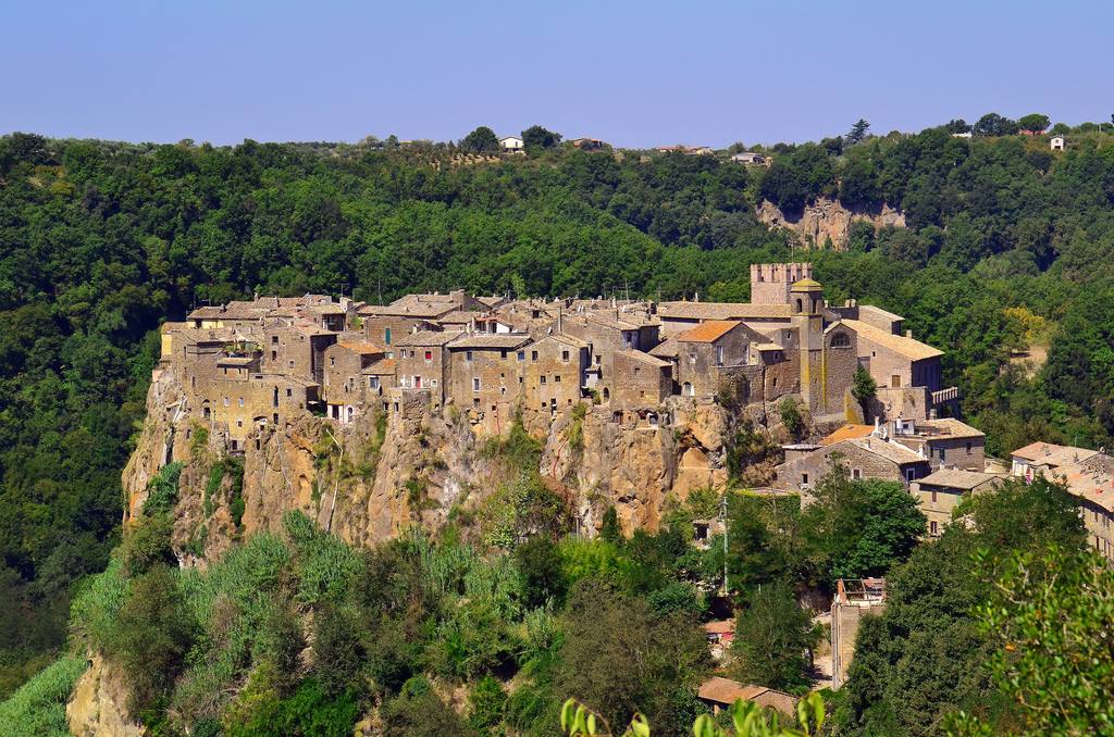 Calcata, borgo medievale di tufo arroccato sulla rupe tra il bosco