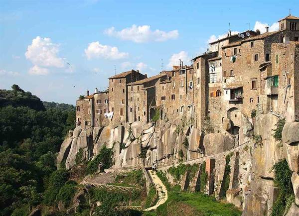Vitorchiano, stone houses built on volcanic rock, blue sky with clouds
