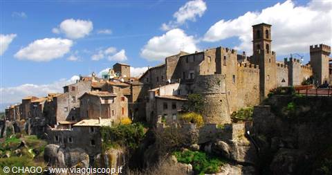Medieval stone village perched on tuff cliff with towers and bell tower, Vitorchiano