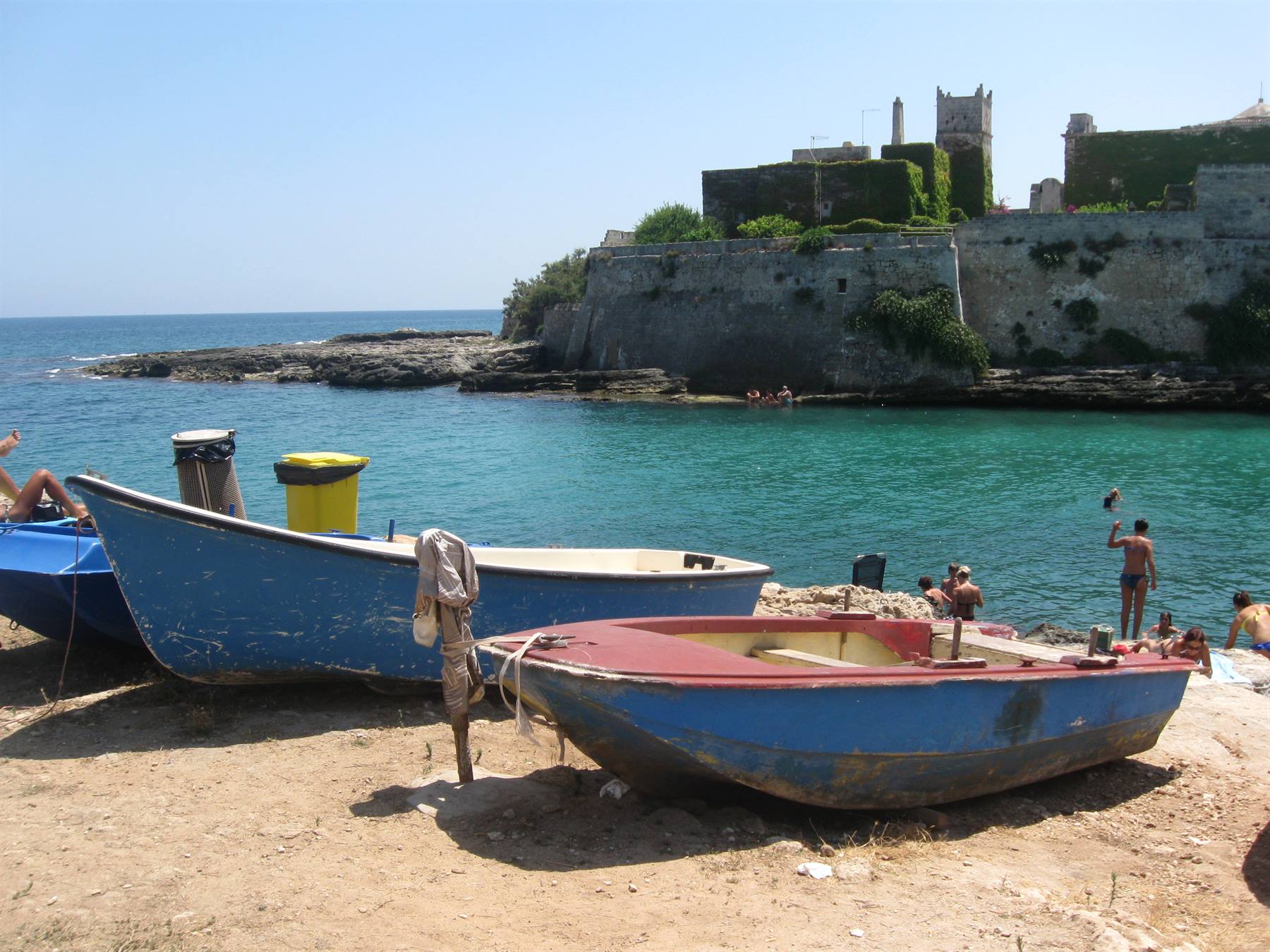 Barche di legno blu sulla spiaggia davanti alla fortezza di Pianosa