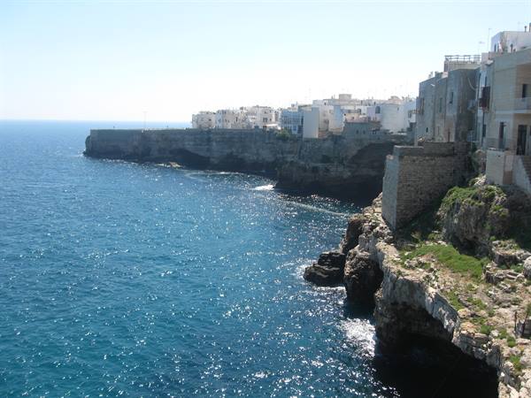 White houses perched on limestone cliffs above the blue sea, Polignano a Mare