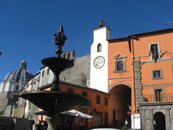 Cast-iron fountain before the clock tower and gate in Montefiascone