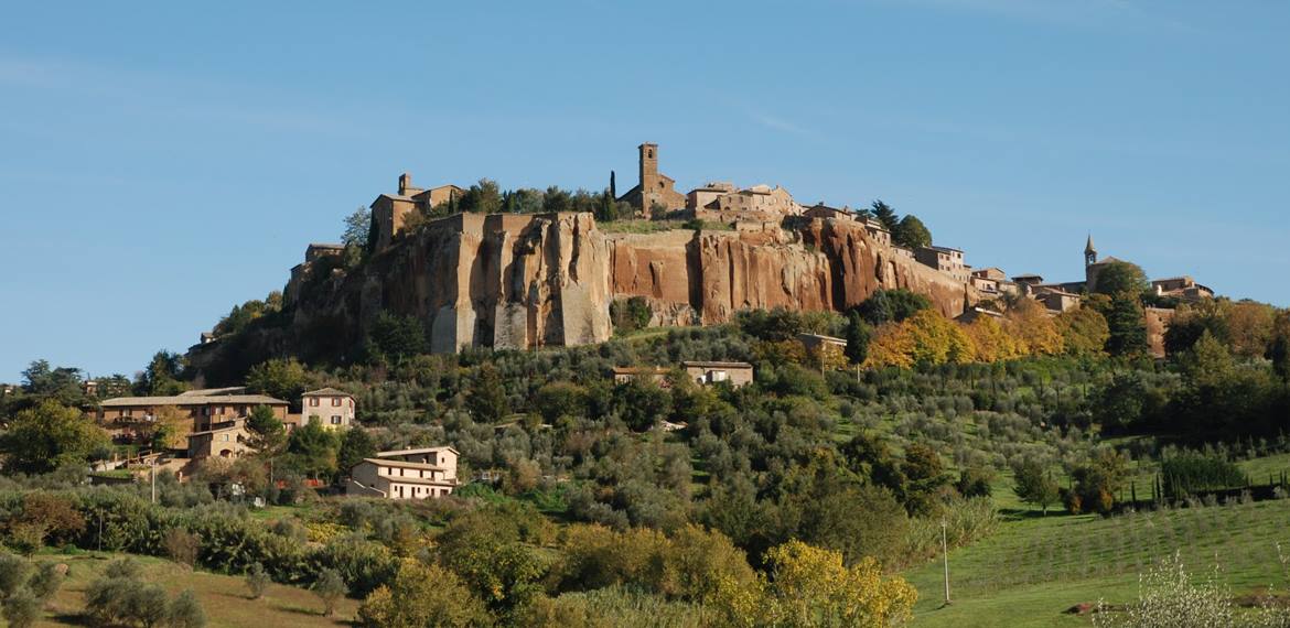 Orvieto, case e campanile sulla rupe di tufo sopra gli uliveti