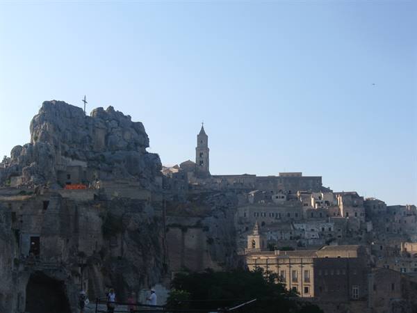 The stone Sassi of Matera with bell tower in morning light