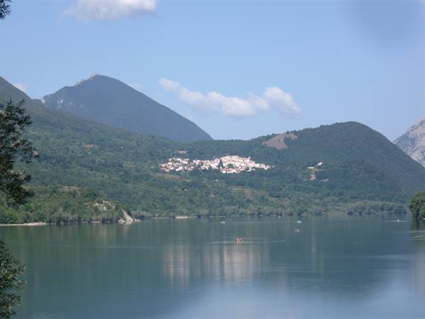 Lake Barrea, small boats on green water and village nestled among mountains
