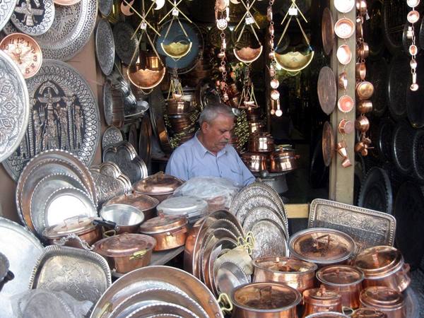 Vendor in his shop of engraved copper pots and trays