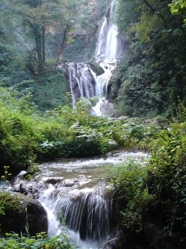 Cascata di Villanova tra rocce muschiose e vegetazione rigogliosa
