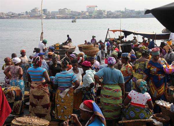 Women with woven baskets selling fish at Freetown harbor