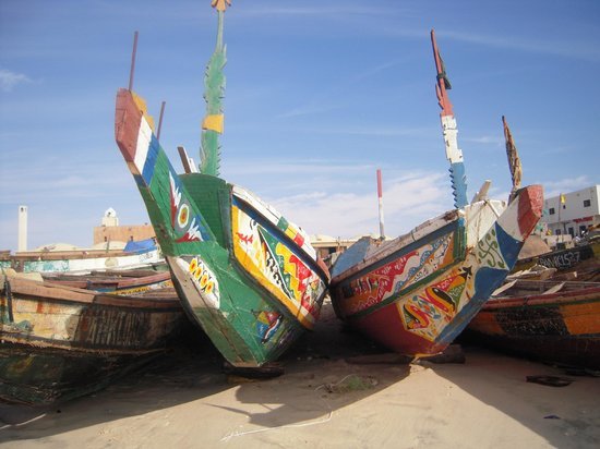 Piroghe da pesca dipinte di verde e rosso varate sulla sabbia