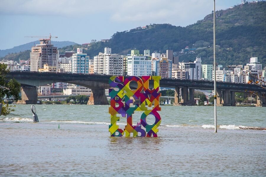 Scultura colorata SOU FLORIPA nell'acqua davanti al ponte Hercílio Luz