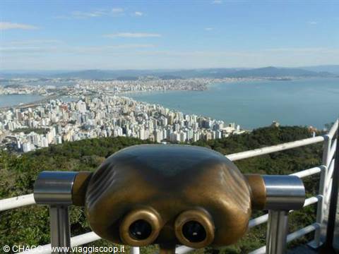 Metal coin-operated binoculars overlooking a coastal city and blue bay