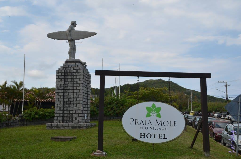 Statua di surfer con tavola su colonna di pietra, insegna hotel Praia Mole