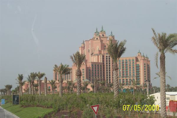 Atlantis The Palm in Dubai, pink hotel among palm trees and gardens under hazy sky