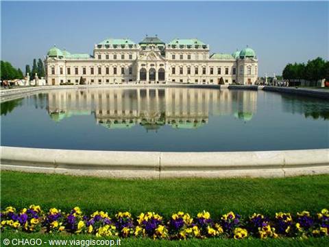 Belvedere Palace in Vienna reflected in the pond among yellow and purple flowers
