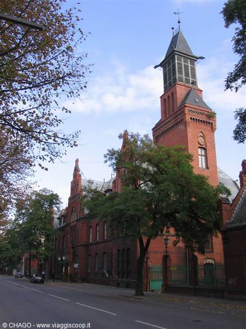 Red brick tower of historic Berlin building among autumn trees