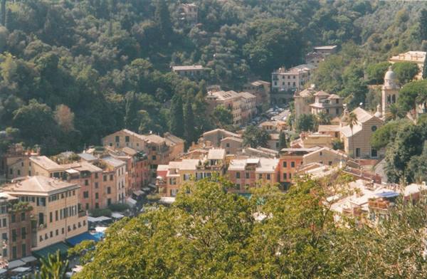Portofino: colorful houses and bell tower among green hillside trees