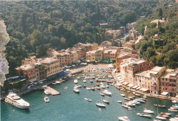 Portofino: boats in the harbor surrounded by colorful houses and green hill