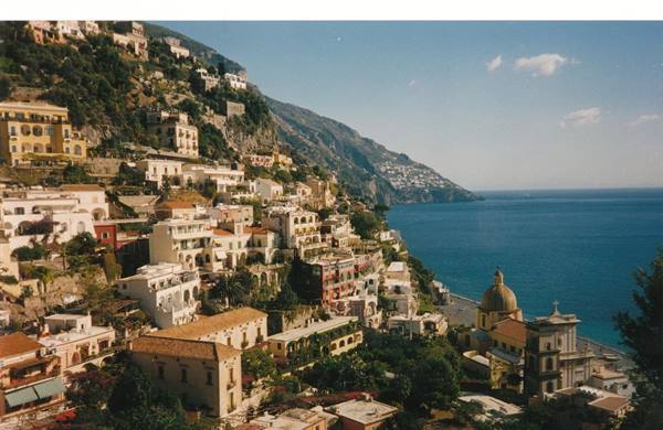 Positano's colorful houses descend to the sea, church dome visible