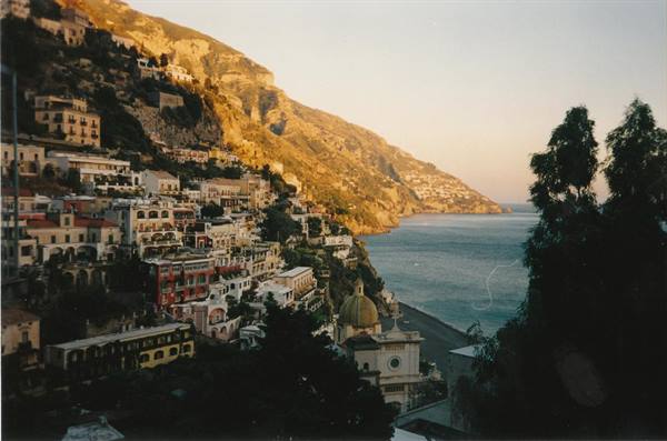 Colorful houses on cliff above Positano beach, golden light