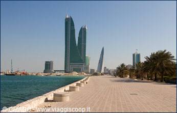 Bahrain World Trade Center twin towers over Manama waterfront with palm trees