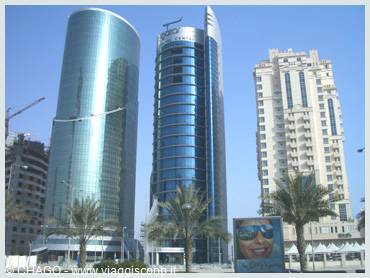 Blue glass skyscrapers and palm trees in Doha, West Bay