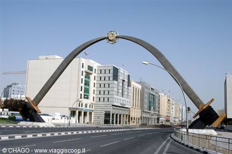 Crossed swords arch over the road, modern buildings in Dubai