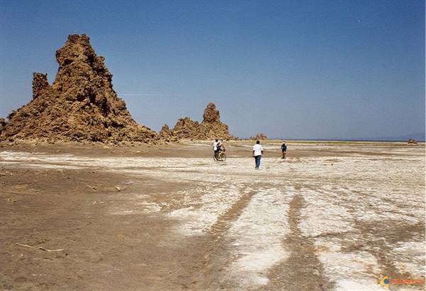 Lake Abbe limestone chimneys, people walking across salt-crusted flats