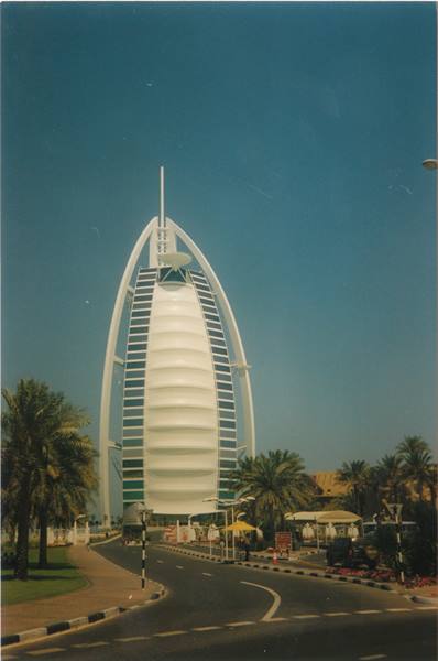Burj Al Arab in Dubai, white sail-shaped facade among palms under blue sky