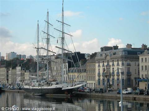 Three-masted tall ship moored at Cherbourg harbour, old buildings reflected in the water